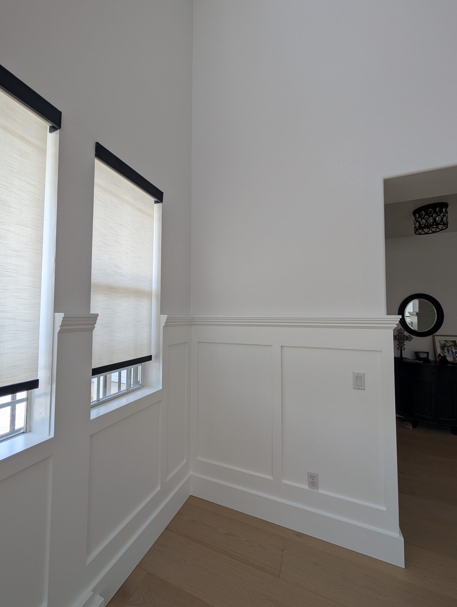 Wainscoting pilaster ending at a window without caulk to leave room for custom window treatments