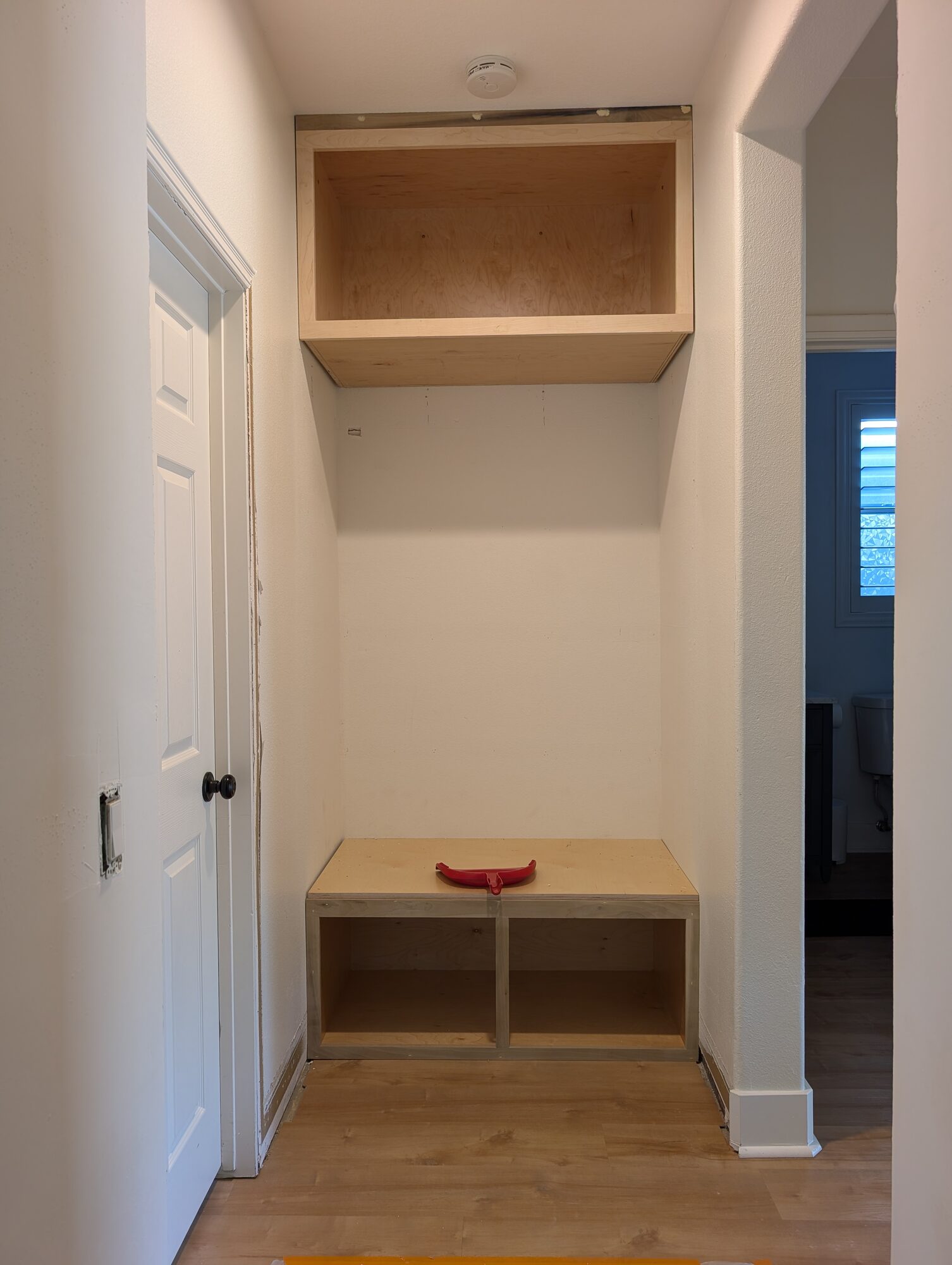 Maple plywood upper box and bench box set into the narrow garage-entry niche at the start, Winchester CA