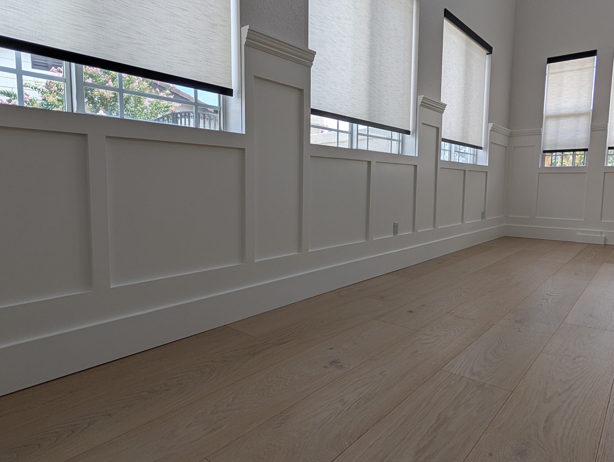 Low view of white wainscoting under dining room windows, panels matched to sill heights, Rancho Cucamonga