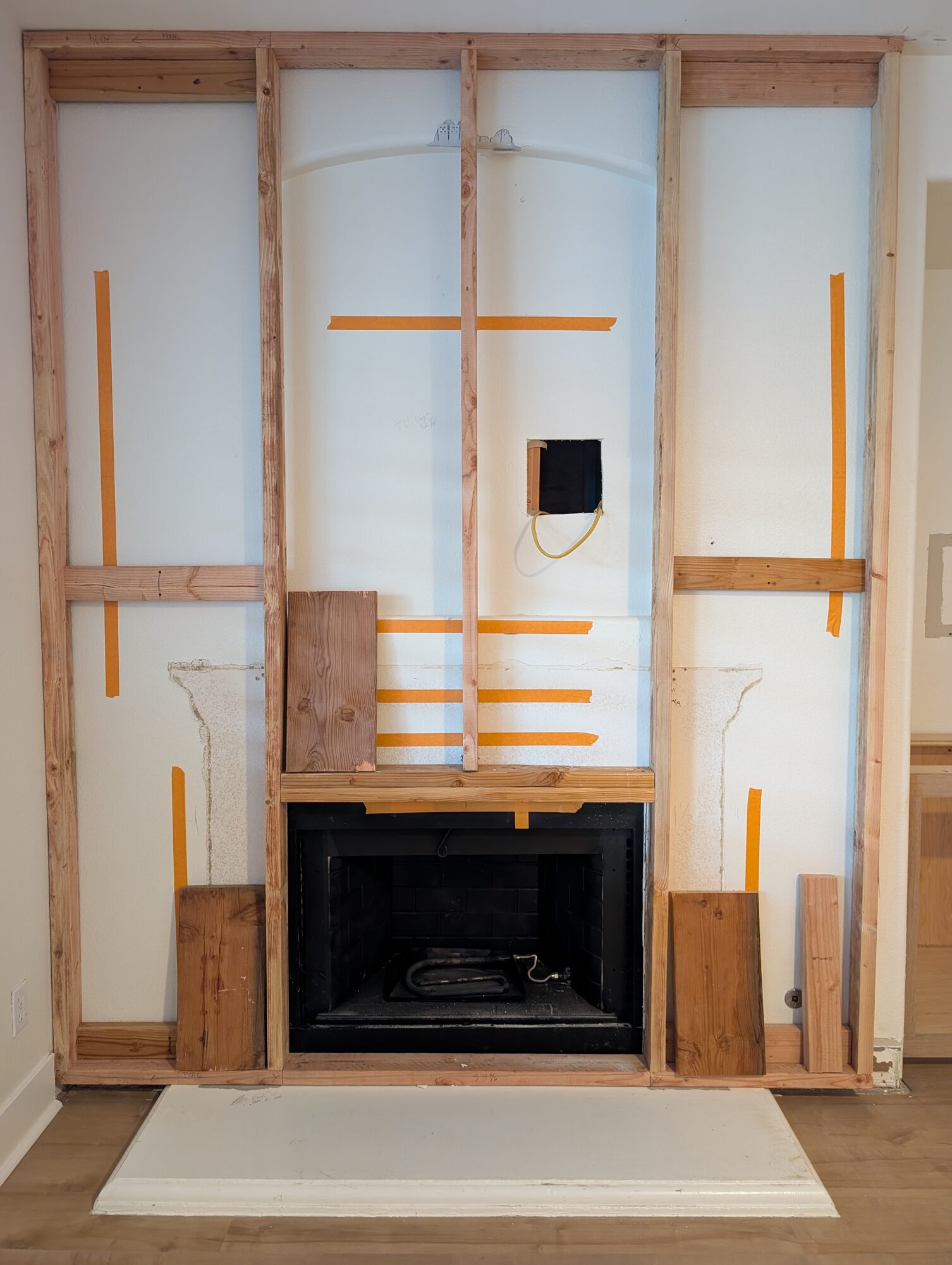 New stud framing over the old fireplace wall, the arched niche and plaster mantel outline still showing, Winchester CA