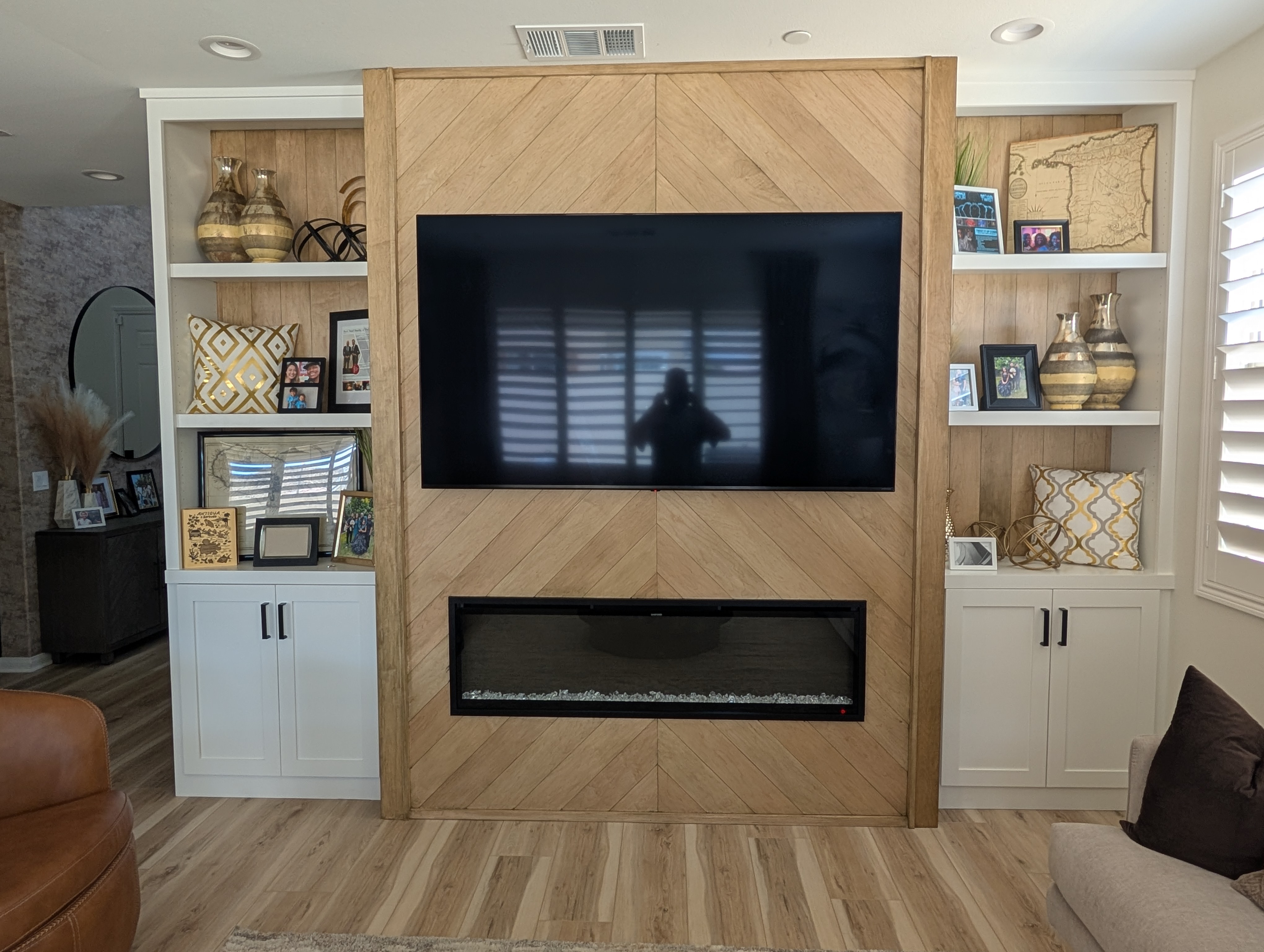 Finished Liberty Bell chevron feature wall with dark-stained maple, electric fireplace, and styled built-in bookshelves, Menifee CA