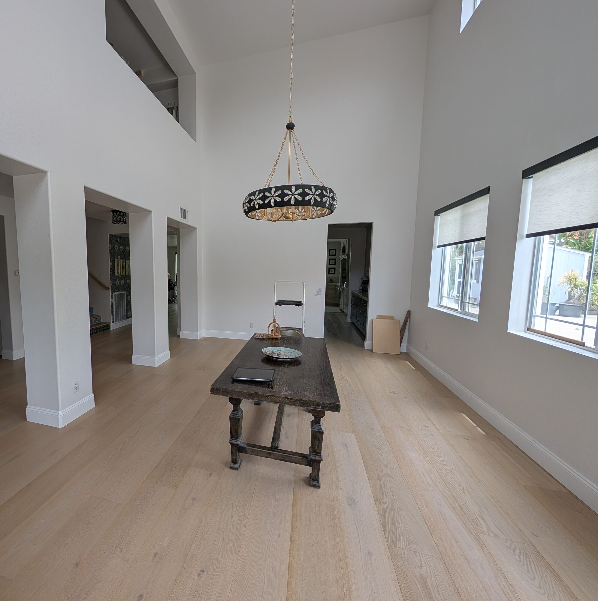 Rancho Cucamonga dining room before wainscoting, bare drywall walls and columns under 20-foot ceilings
