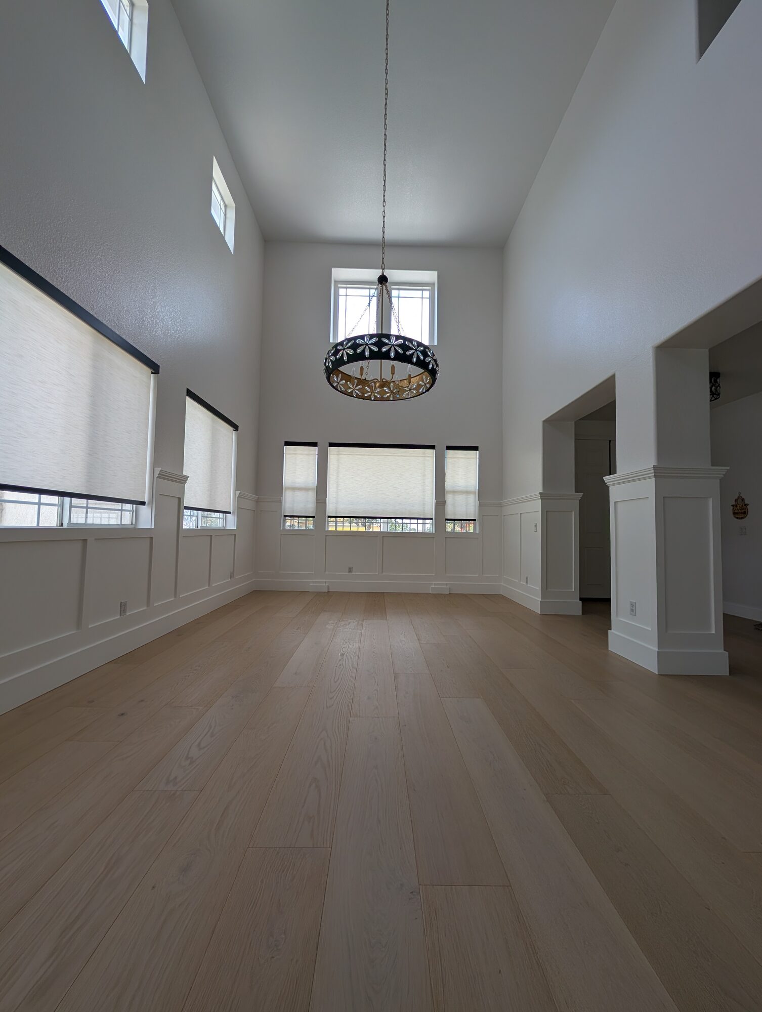 Finished white flat-panel wainscoting around a two-story dining room in Rancho Cucamonga, CA