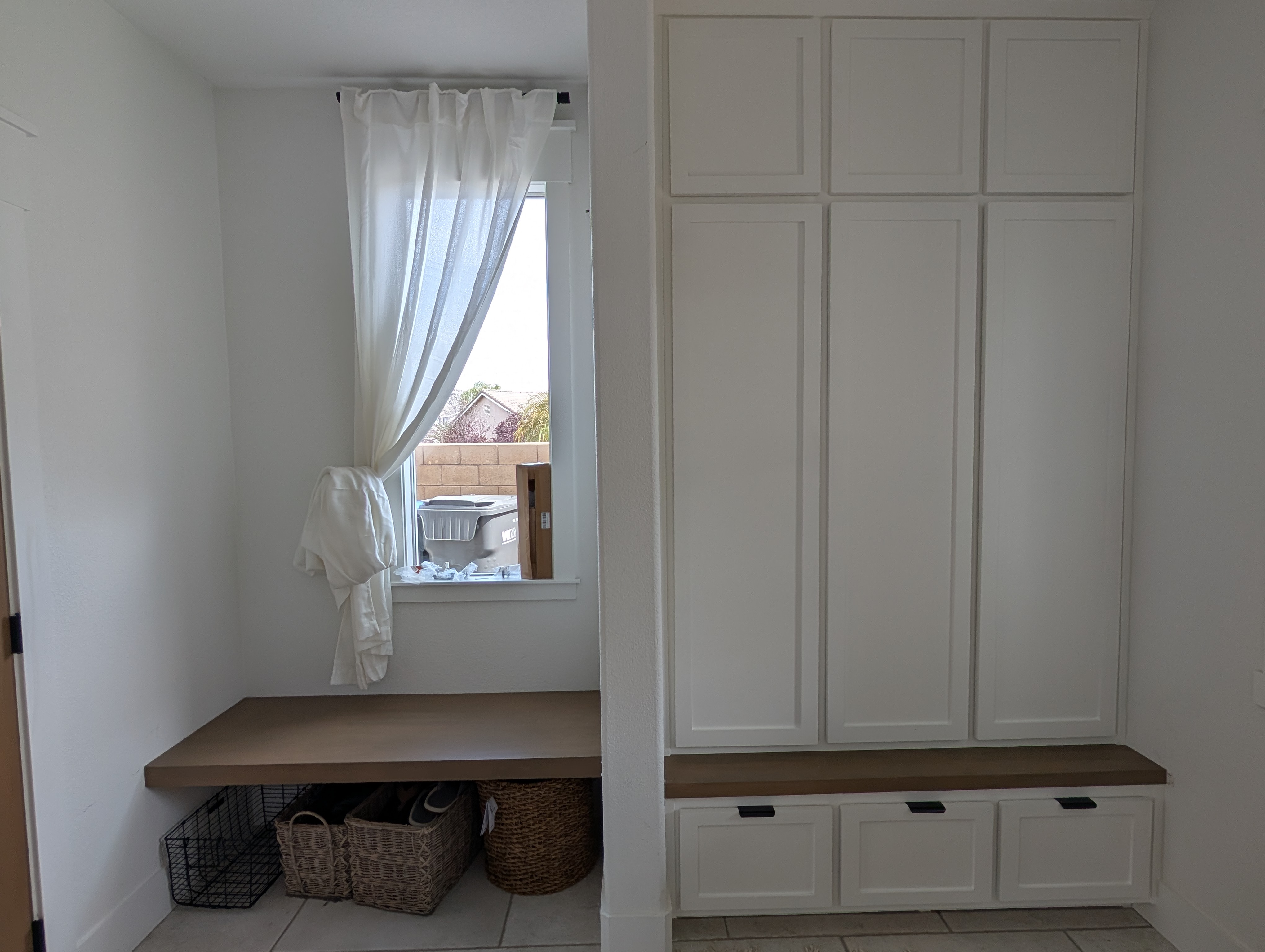 Finished mudroom bench and open lockers styled with storage baskets, Menifee CA