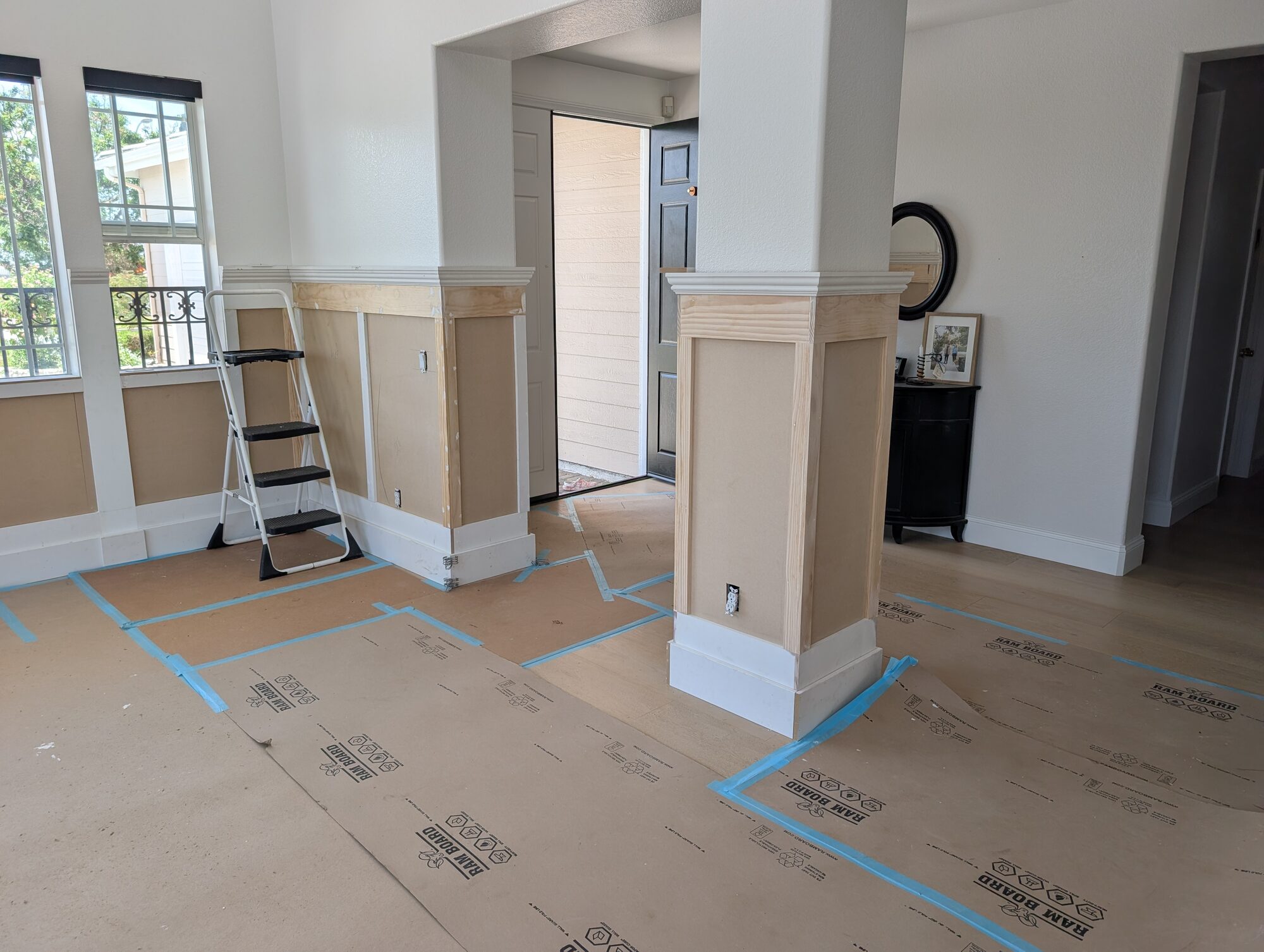 Paneled column wrap in raw pine and MDF during wainscoting install near entry, Rancho Cucamonga home