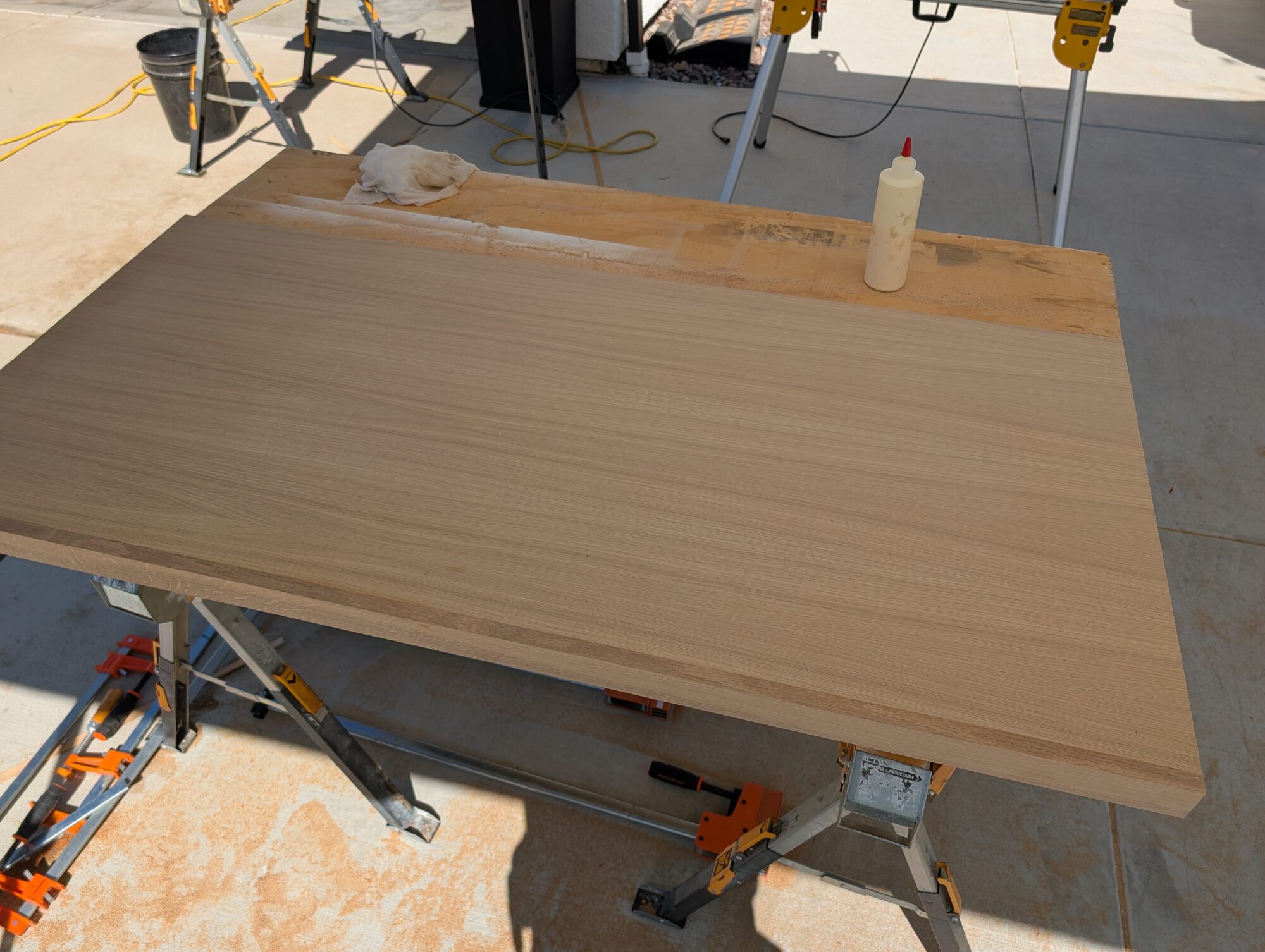 Miter-folded rift-sawn white oak bench top glued up on sawhorses in the driveway shop, Winchester CA