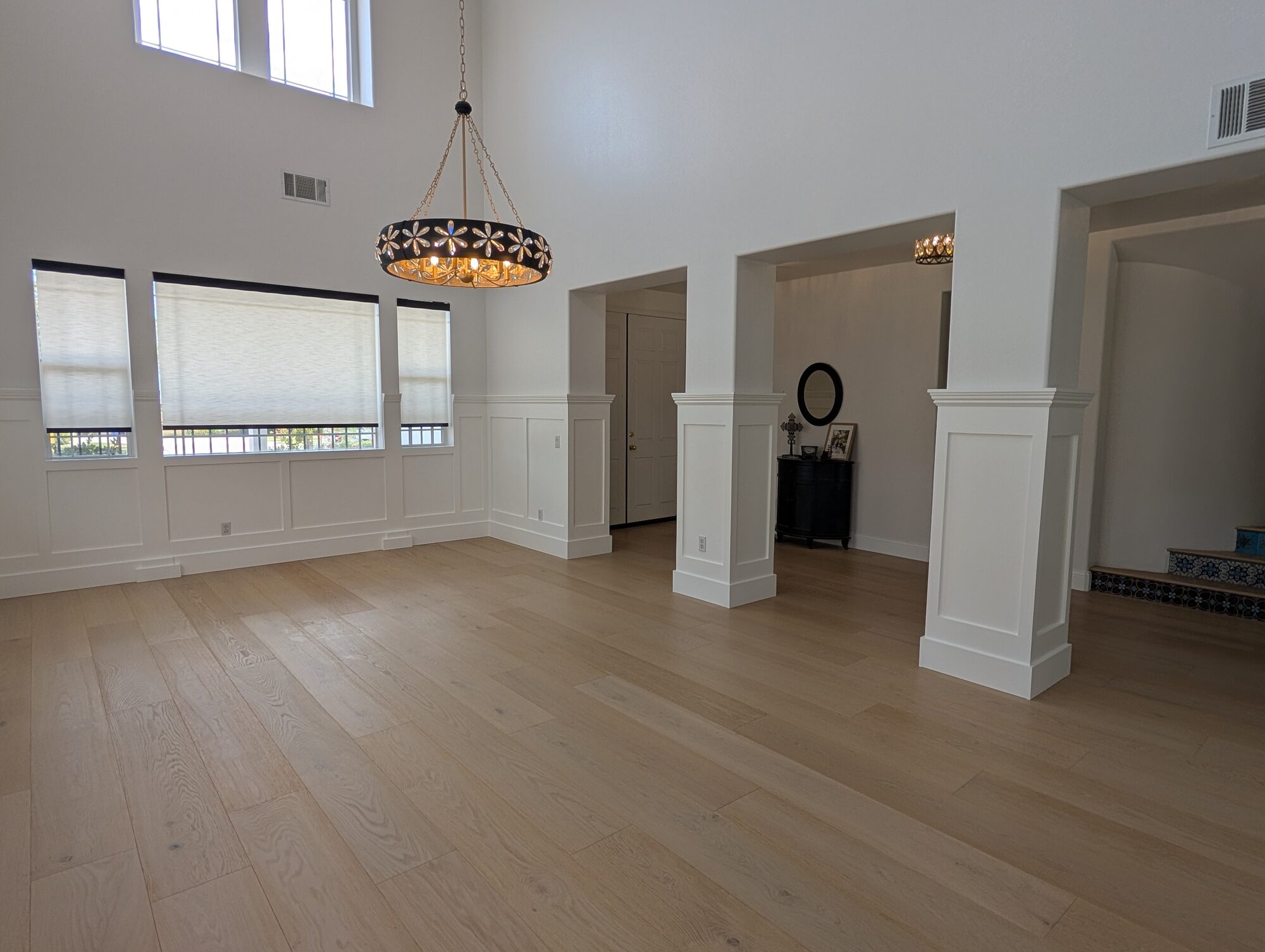 Finished dining room wainscoting with paneled columns and chandelier in a Rancho Cucamonga home
