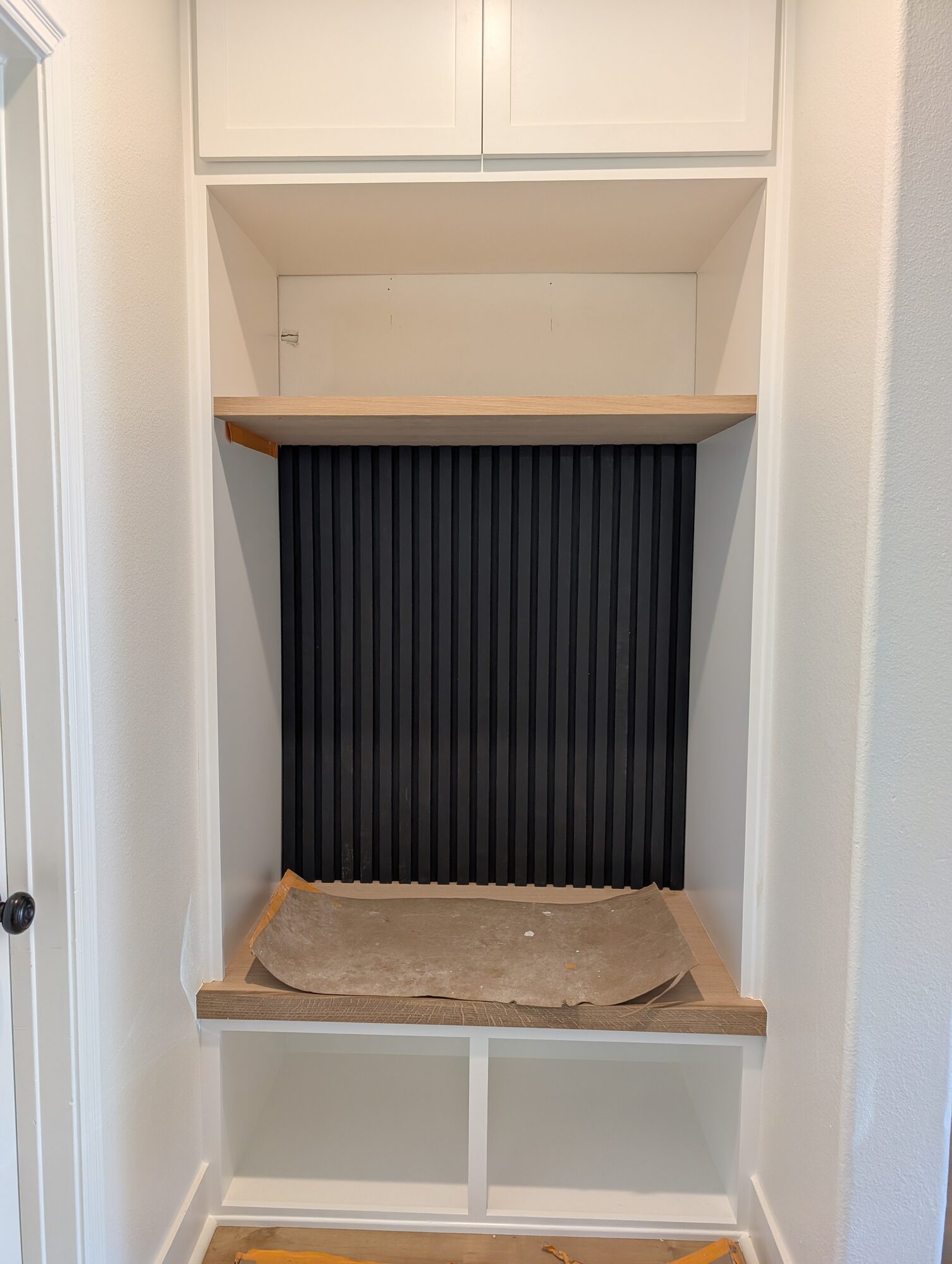 White paint on the cubbies and the lower black slat wall installed behind the oak bench, Winchester CA