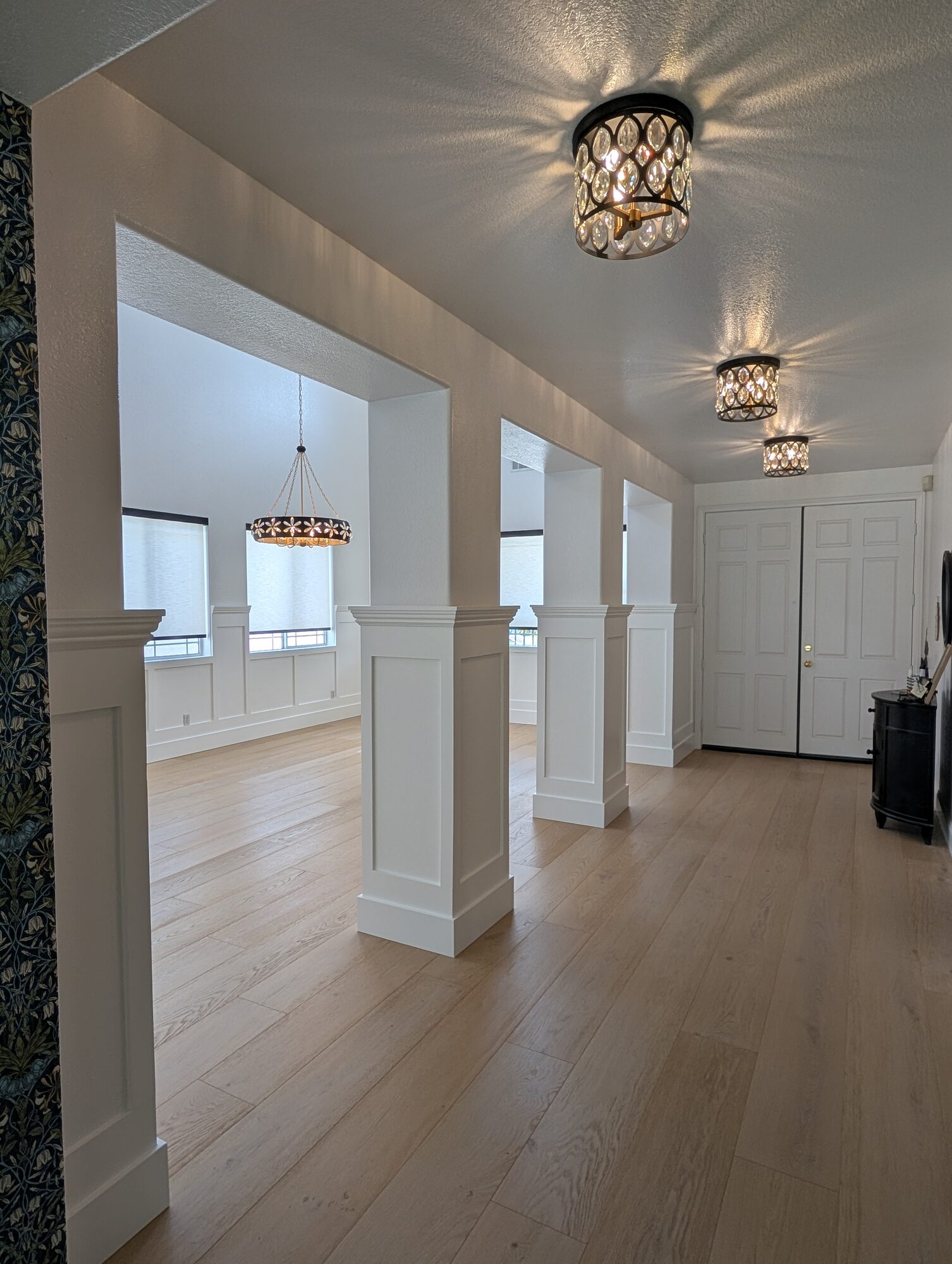 Entry hall view through paneled columns into dining room with white wainscoting, Rancho Cucamonga