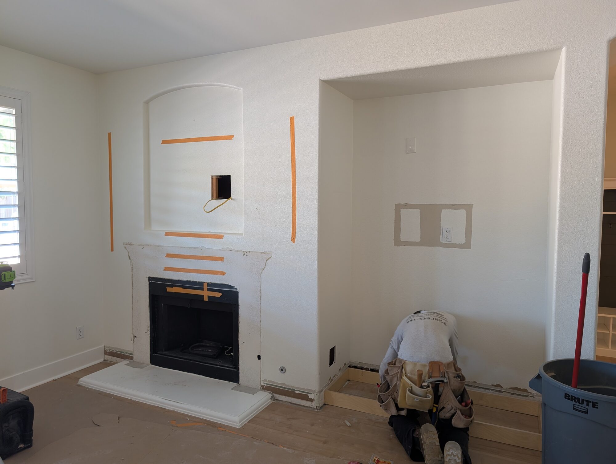 Original builder-grade fireplace wall with arched TV niche, plaster mantel surround and bare alcove, Winchester CA