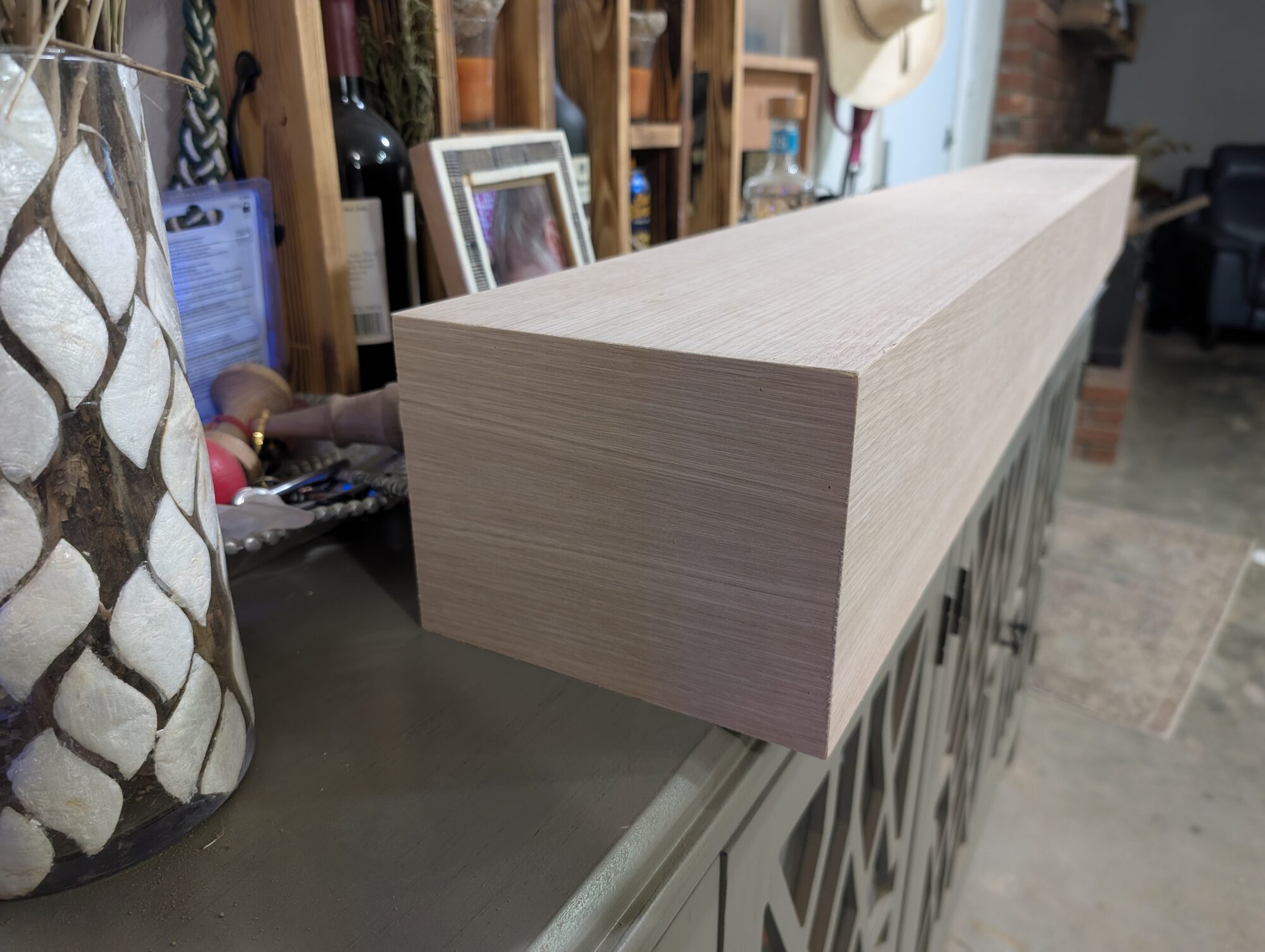 Floating white oak mantel in the shop, its mitered corner wrapping the grain around the return, Winchester CA